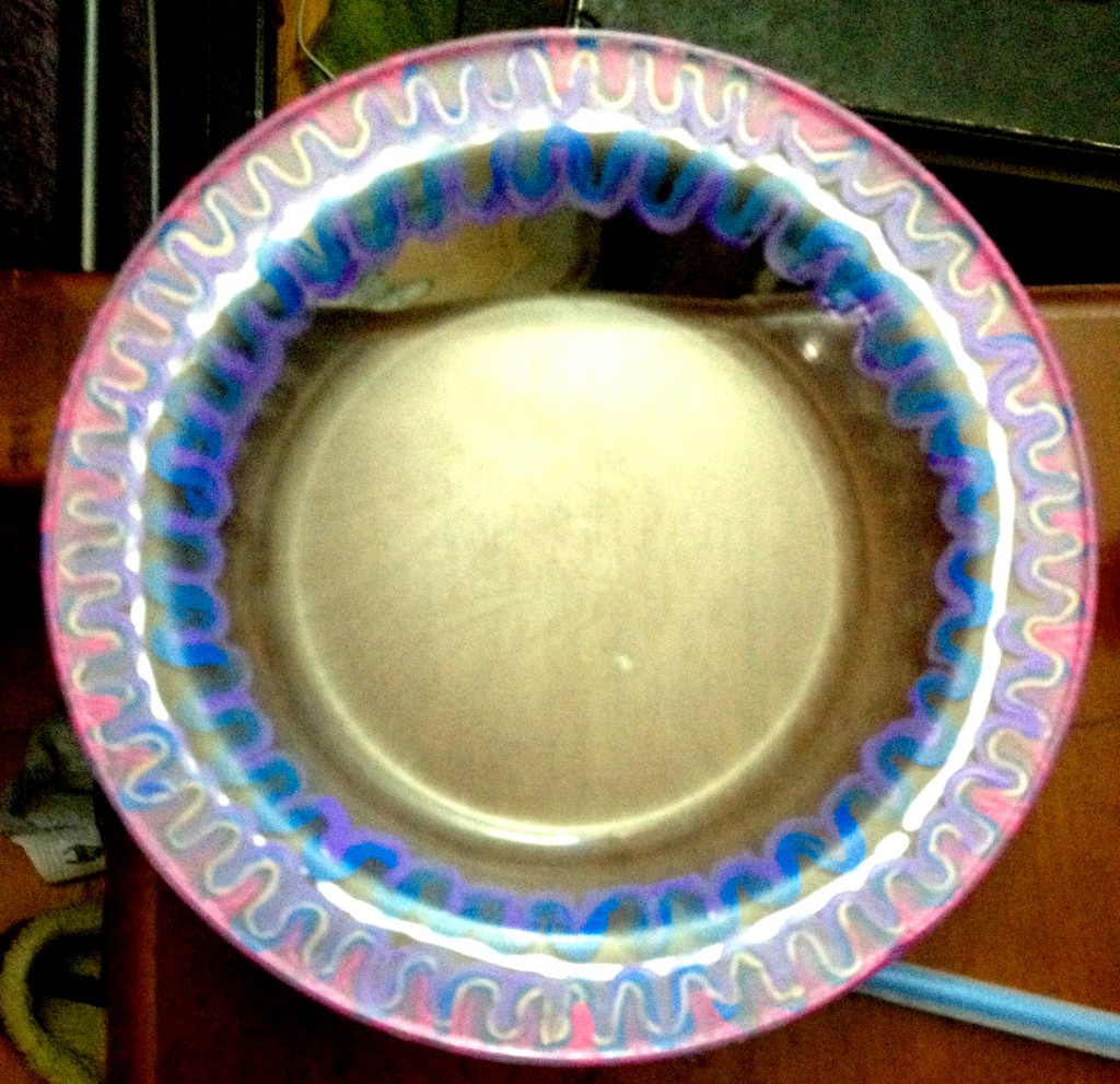 Photo of a partially painted glass plate.